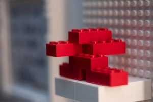 Construcción de piezas LEGO simbolizando módulos principales de ERP Estructura de LEGO en construcción, representando los módulos principales de un sistema ERP con Finanzas, Ventas, Compras y Producción.